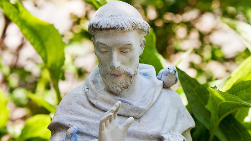 En staty av en harmonisk Franciscus av Assisi med f�glar sittande p� ena axeln och armen.